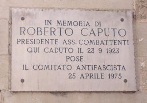 Tricase - Palazzo Gallone -  Lapide che il Comitato antifascista pose il 25 aprile 1975 sul prospetto laterale del castello, in memoria di Roberto Caputo, Presidente Associazione Combattenti, qui caduto il 23 settembre del 1923